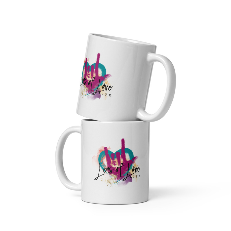 White ceramic mug with the original Lens of Love heart artwork