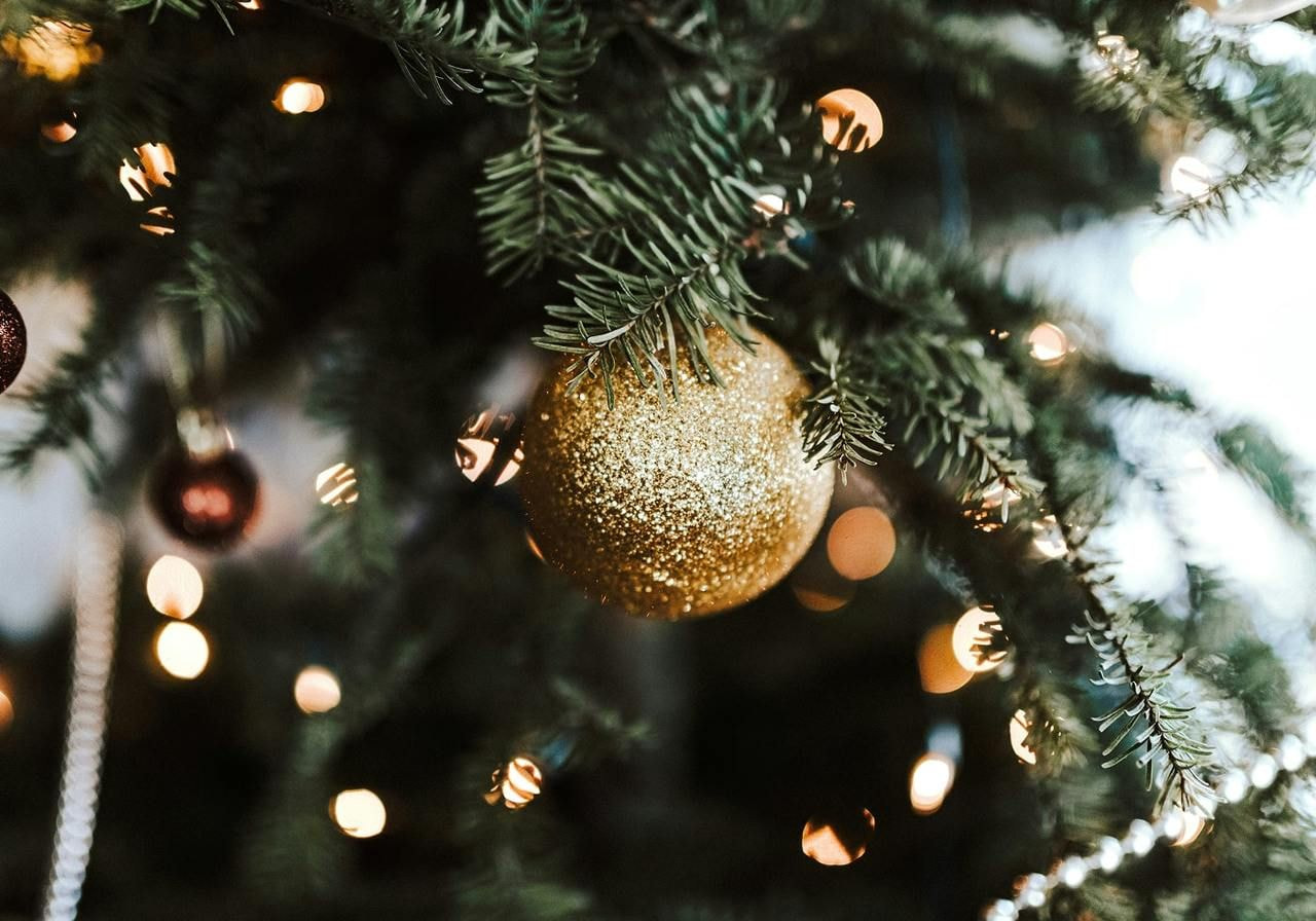 A close-up of a Christmas tree adorned with shimmering gold ornaments, highlighting the festive decorations.
