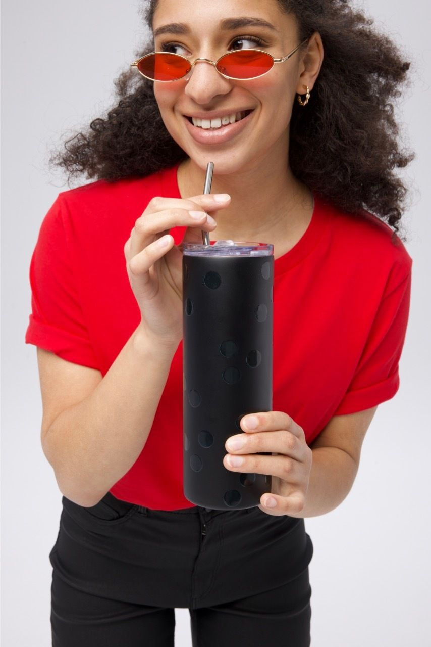 a girl holding a black tumbler