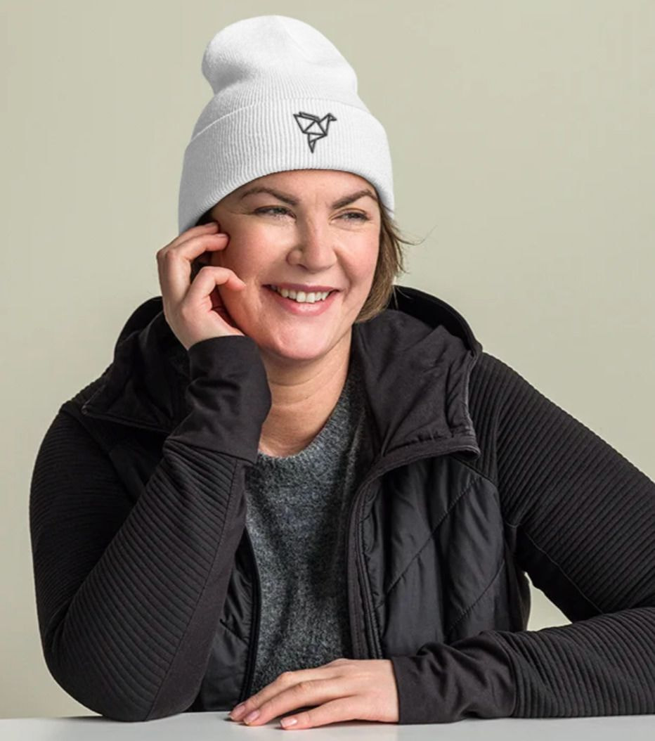 a woman wearing a white beanie and black jacket