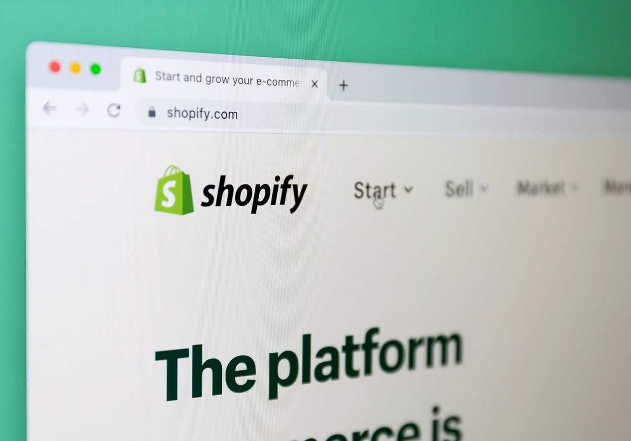 A close-up shot of an internet browser with the Shopify homepage on a laptop screen.