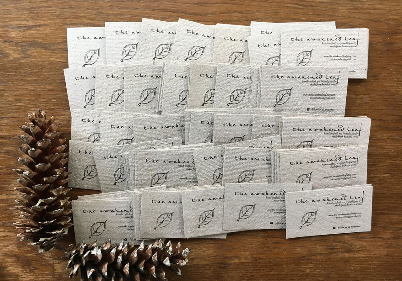 A stack of business cards topped with a pine cone, showcasing a unique blend of nature and professional identity.