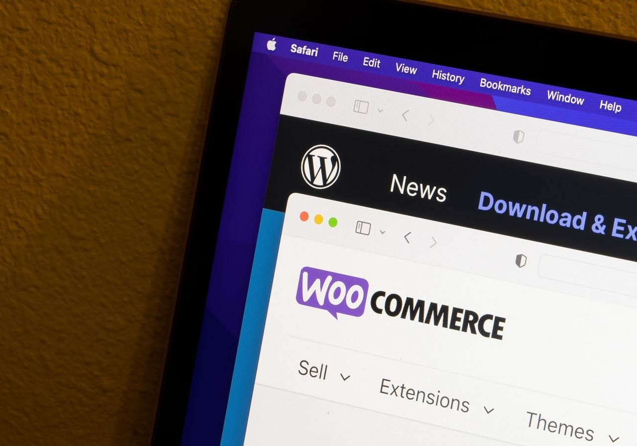 A close-up shot of the WooCommerce logo on a corner of a laptop screen.