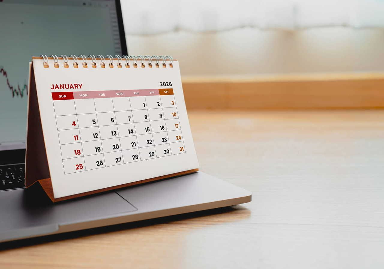 A desk calendar with Jan 2026 open, standing on a corner of a laptop.