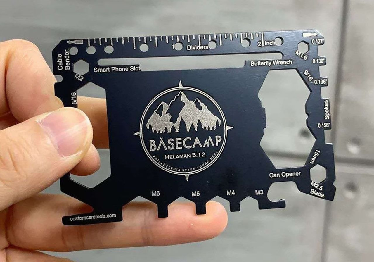 A person holds a metal card featuring the Basecamp logo, showcasing a sleek design and modern branding.