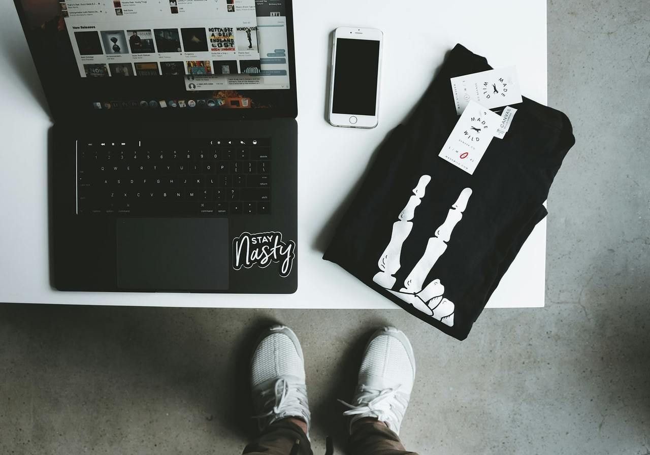 A t-shirt lying on a table near a laptop.