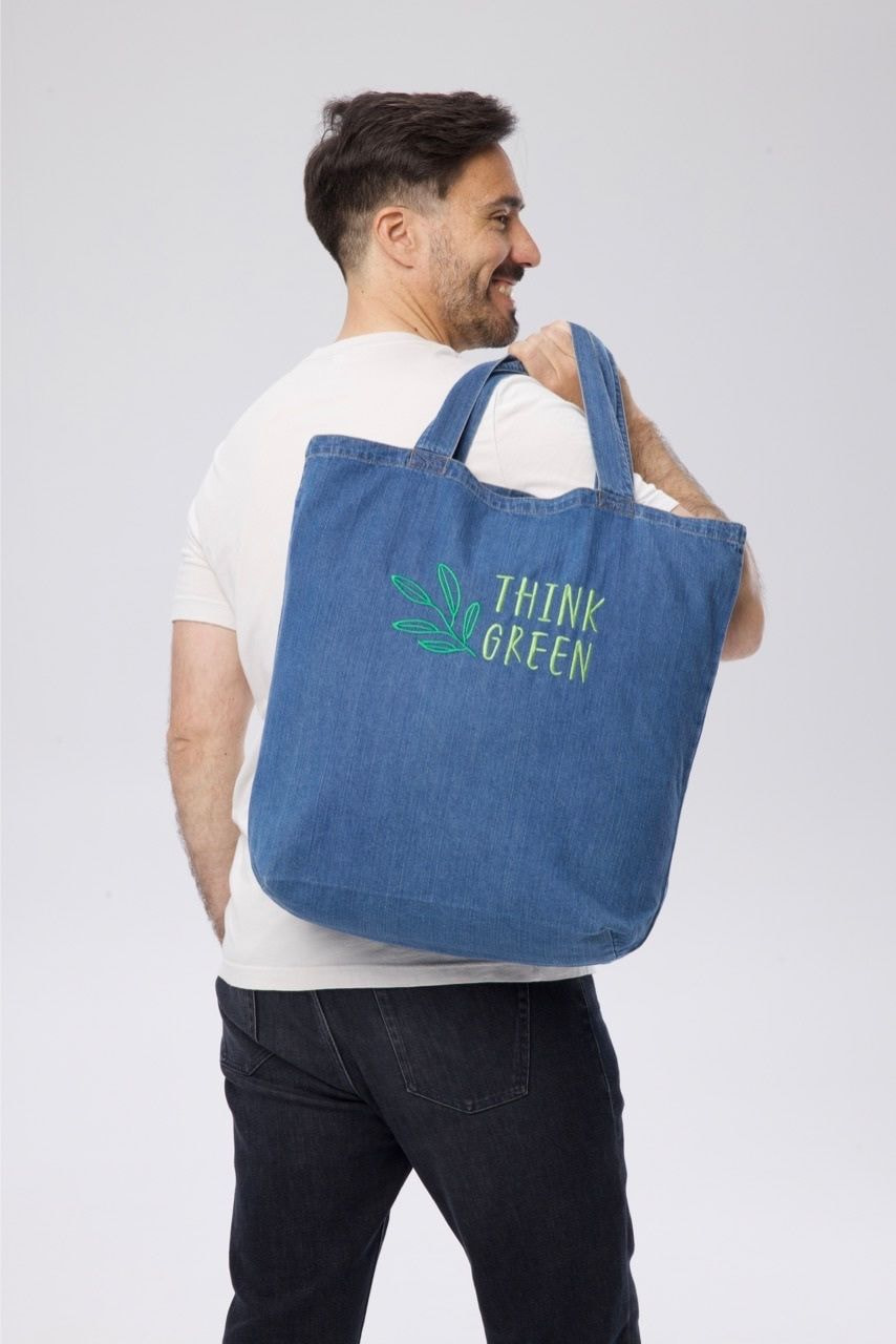 man holding an embroidered tote 