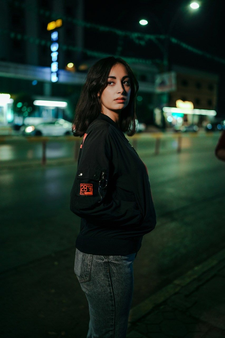 a woman standing on a street at night