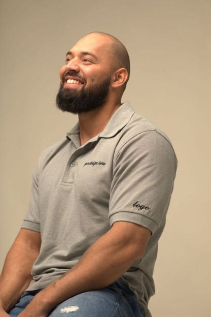 man looking up, wearing an embroidered polo shirt