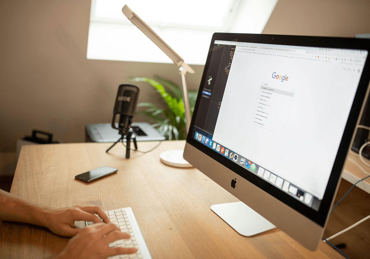 A woman's hands typing on a laptop keyboard, focused on her work.