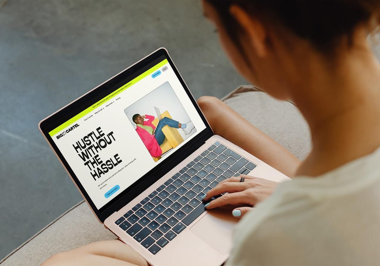 A person is using a laptop with Big Cartel’s homepage on the screen.
