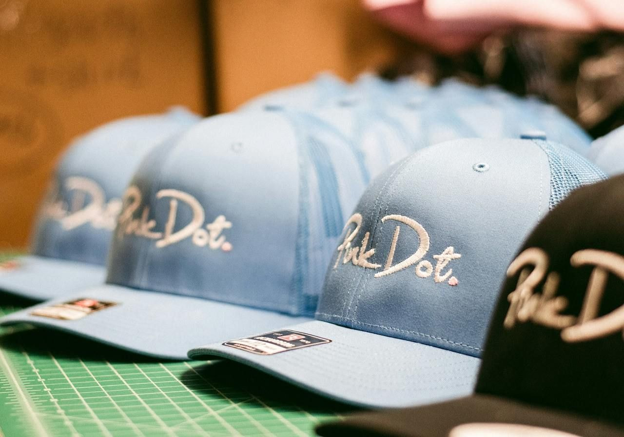 Multiple blue hats with embroidered logos.