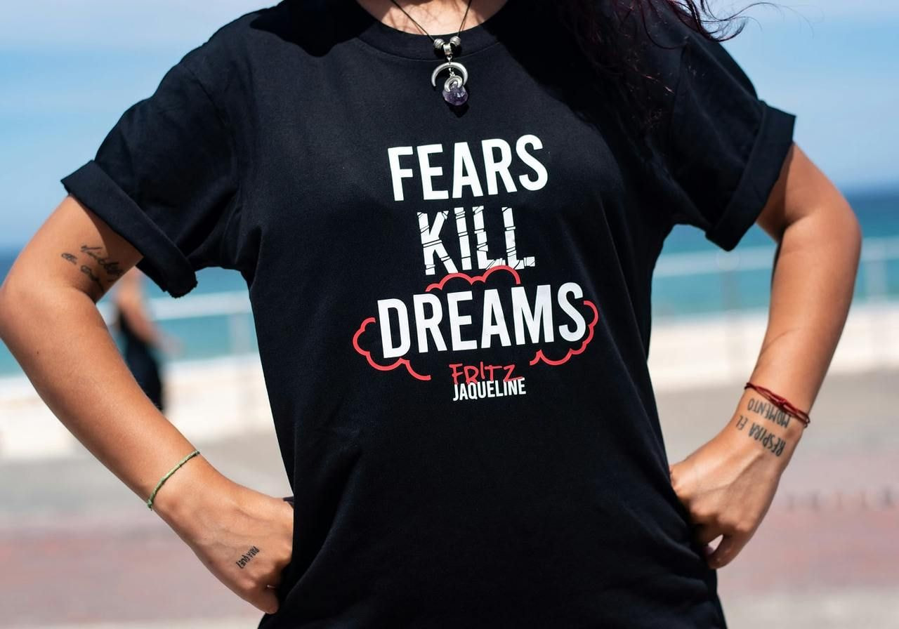 A woman wearing a black “Fear kills dreams” t-shirt.