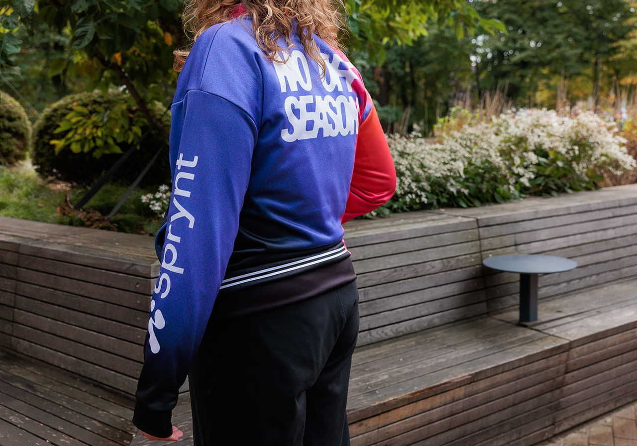 A person wearing a colorful jacket with the text 