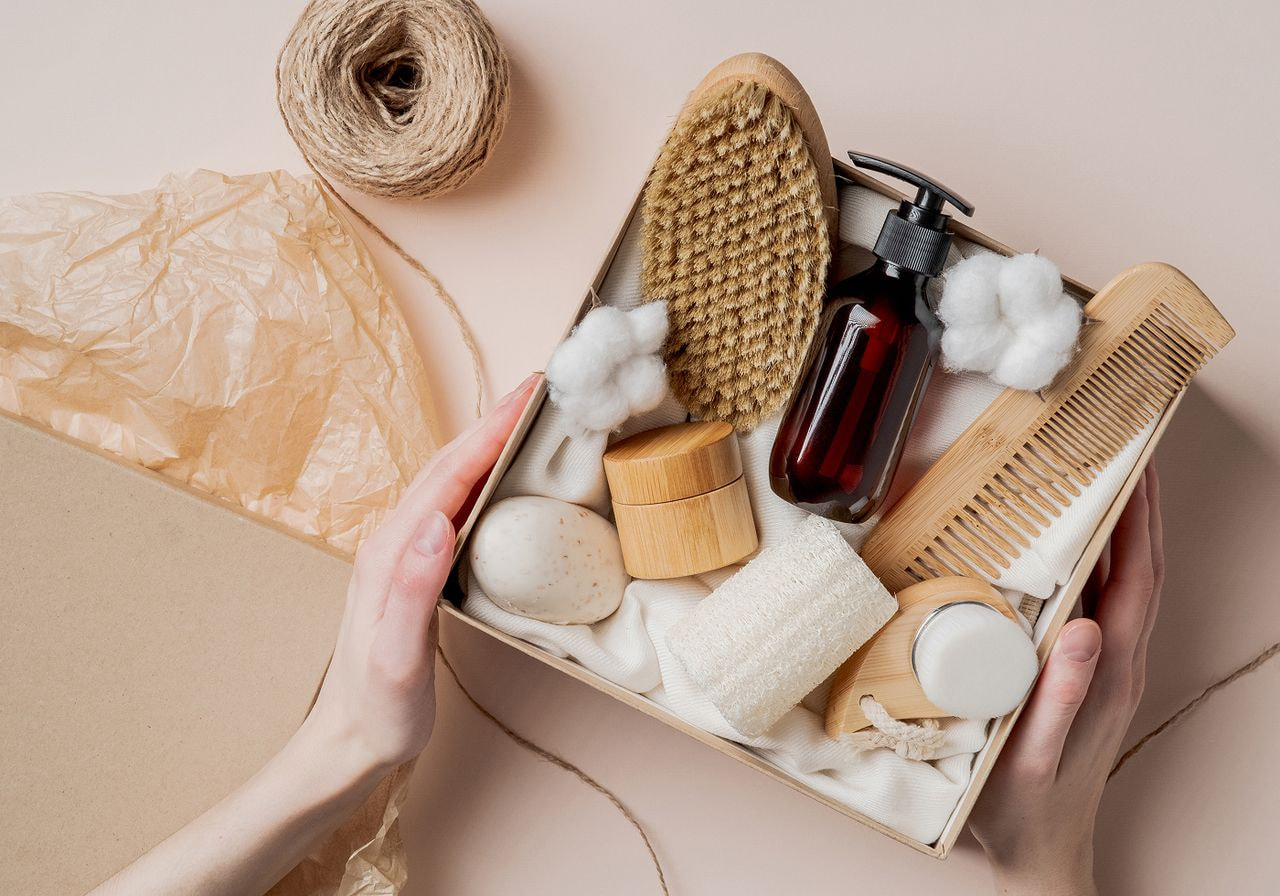 Woman's hands holding a box filled with assorted items, showcasing a variety of colors and textures.