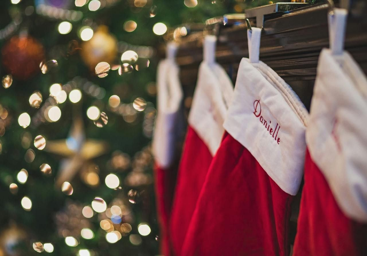Colorful Christmas stockings are hung on a decorated tree, adding a festive touch to the holiday atmosphere.
