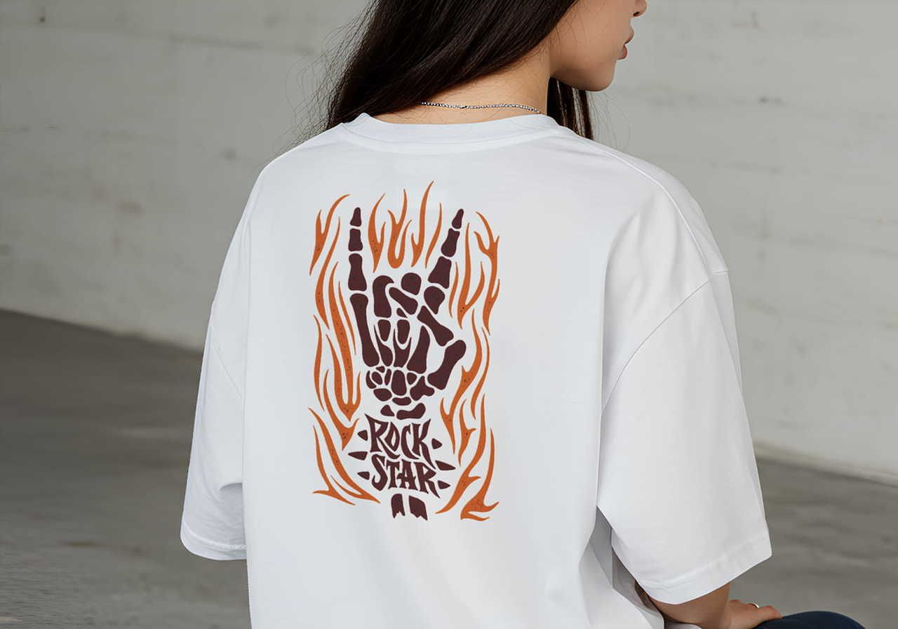 A woman is sitting sideways, wearing a white t-shirt with a graphic on the back featuring the word "Rock Star" beneath.