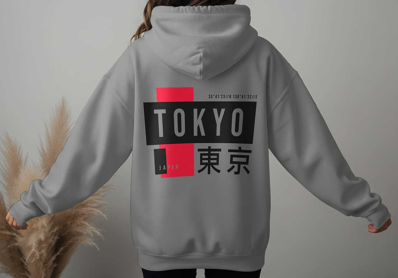 Rear view of a woman wearing a gray hoodie with "TOKYO" in bold letters, black and red accents, and Japanese characters.