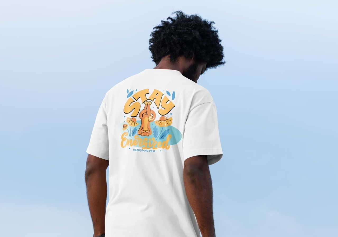 A person wearing a white t-shirt with a colorful graphic design featuring the text 'Stay Energized' and a headstand pose illustration.