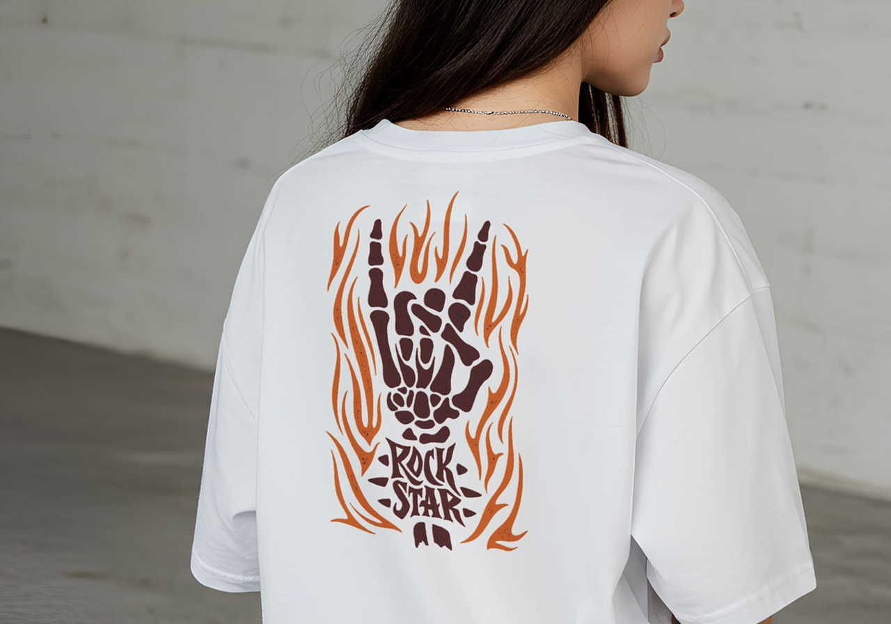 A woman wearing a white t-shirt featuring a skeletal hand gesture with flame designs and the words "Rock Star" on the back.