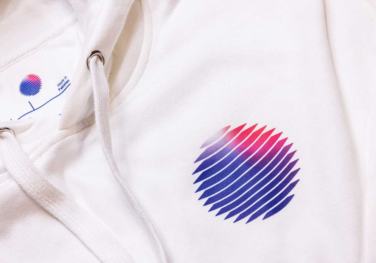 A close-up of a white hoodie featuring a colorful graphic design of a circular shape with wavy lines in red and blue.