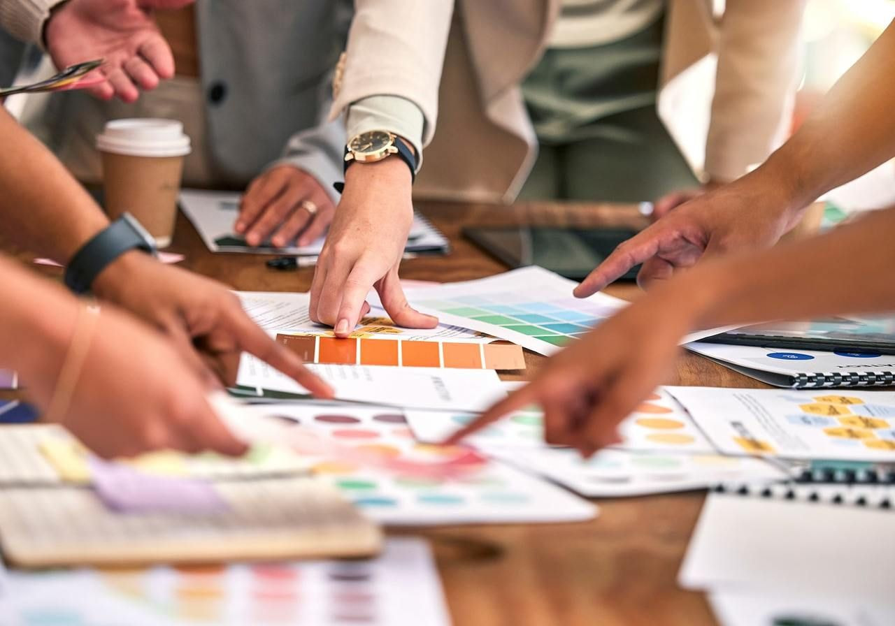 A group of people pointing at different printouts.