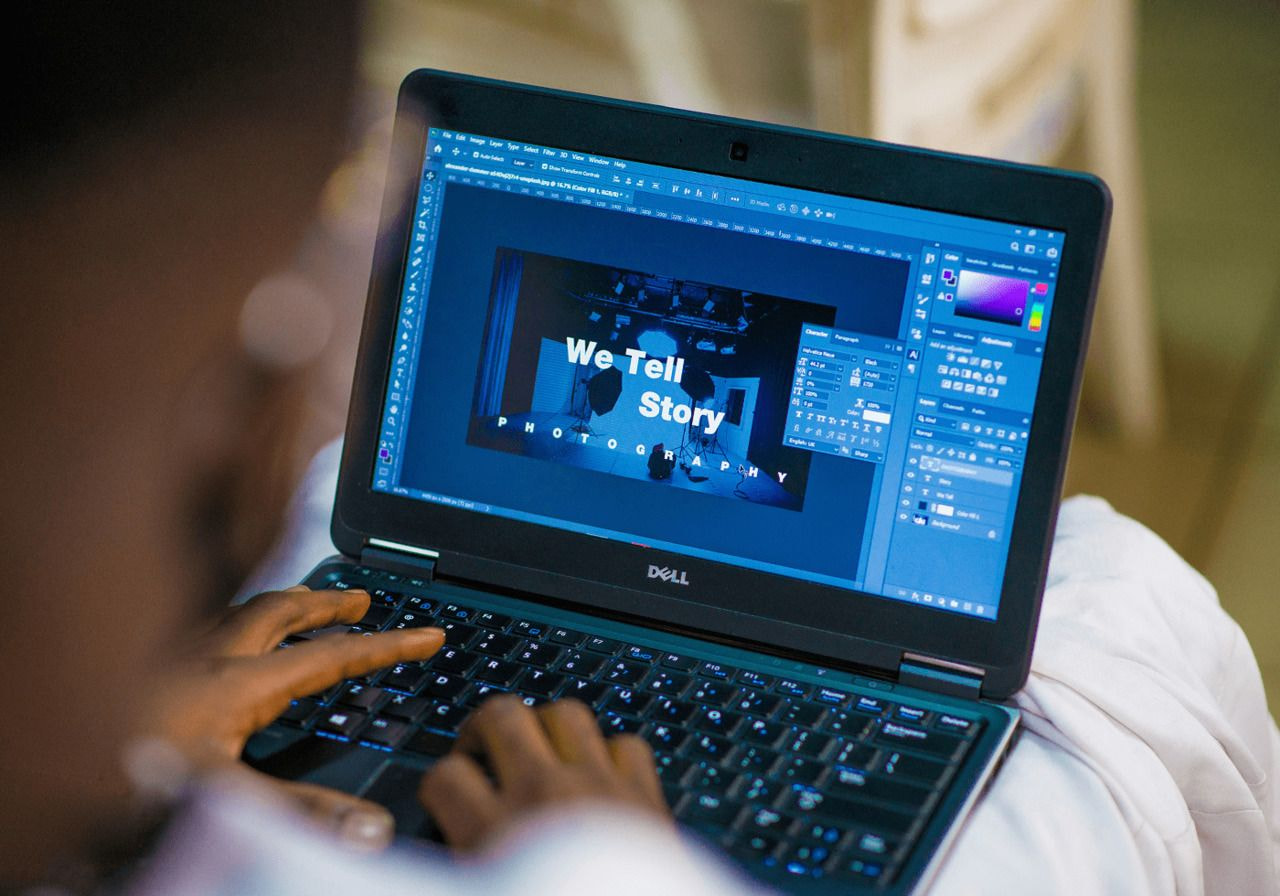 A person focused on a laptop computer, typing and engaged in work or research.
