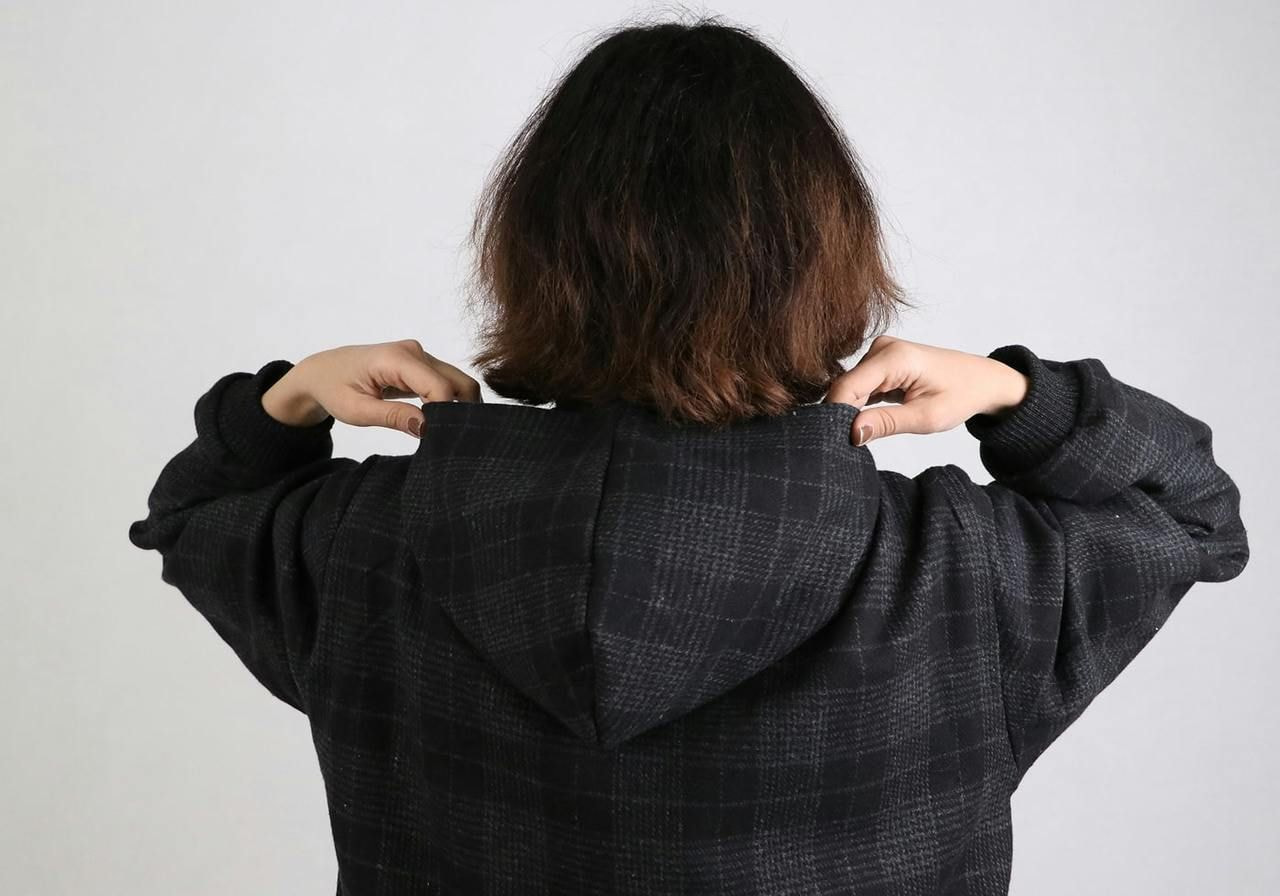 Back view of a woman in a black and white checkered jacket, showcasing the pattern and style of the garment.