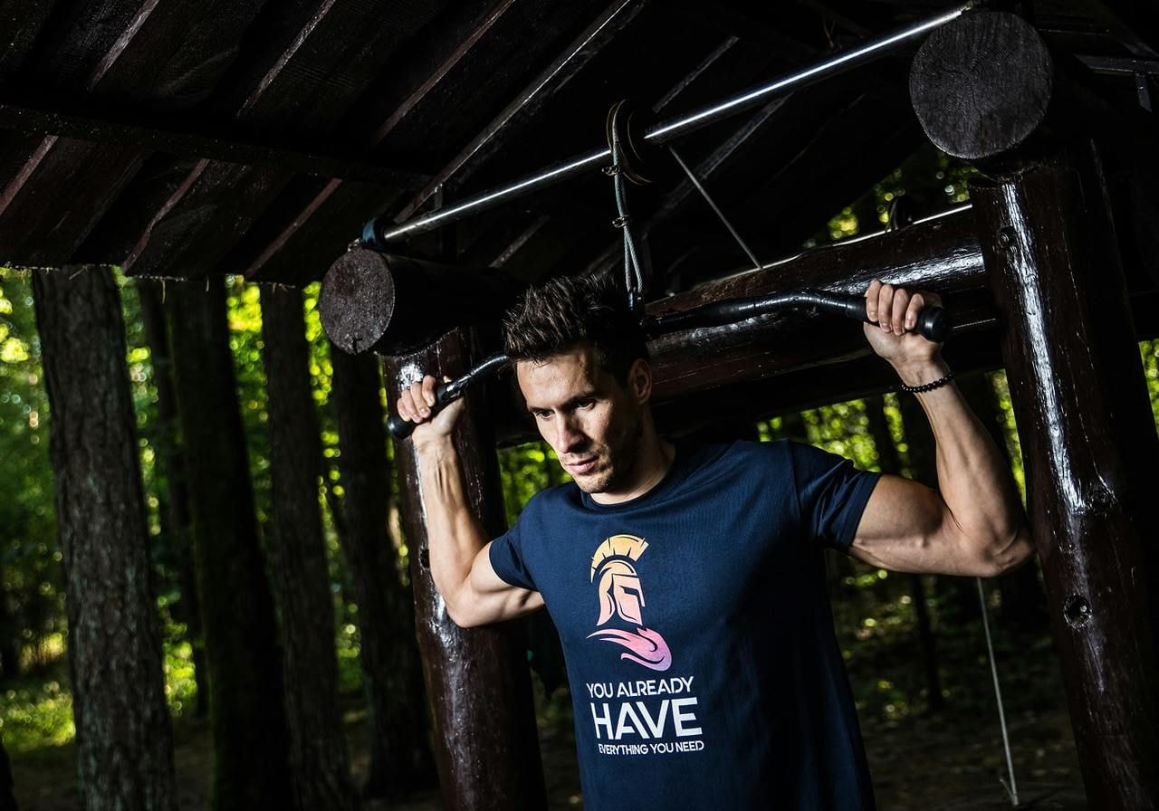 A man is working out while wearing a blue t-shirt with a custom print.