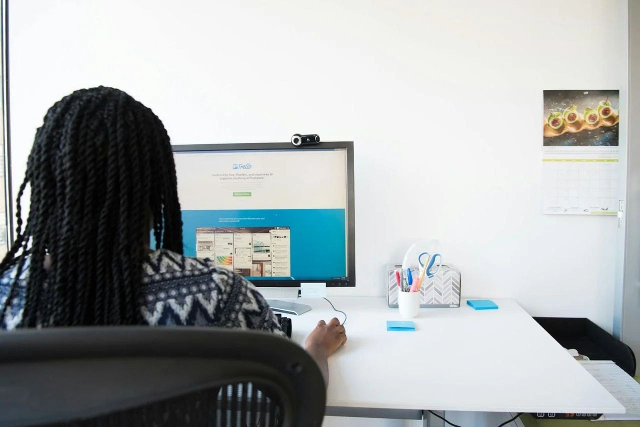 Eine Frau, die an einem Schreibtisch sitzt und einen Computer benutzt
