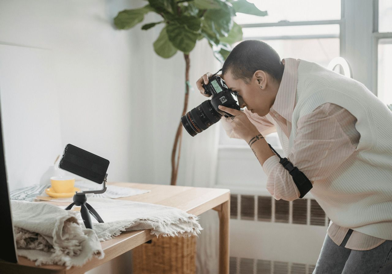 A woman taking a picture of fabrics with a professional camera.
