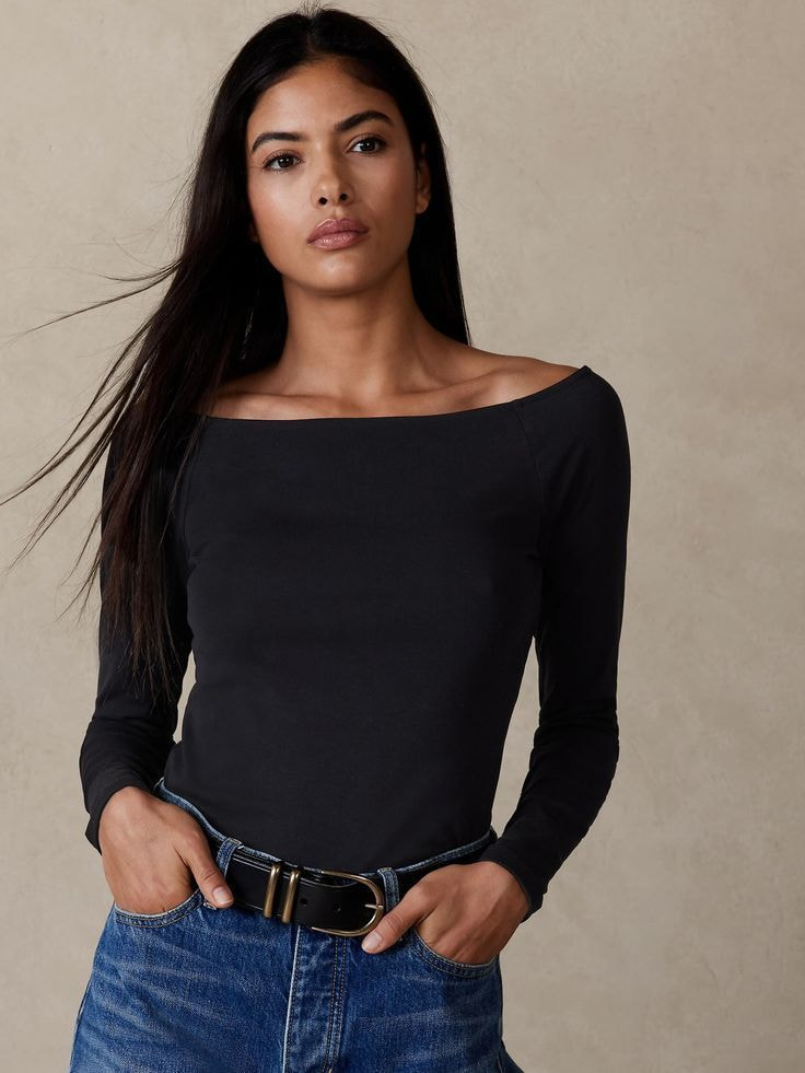 a woman wearing a black boat-neck t-shirt