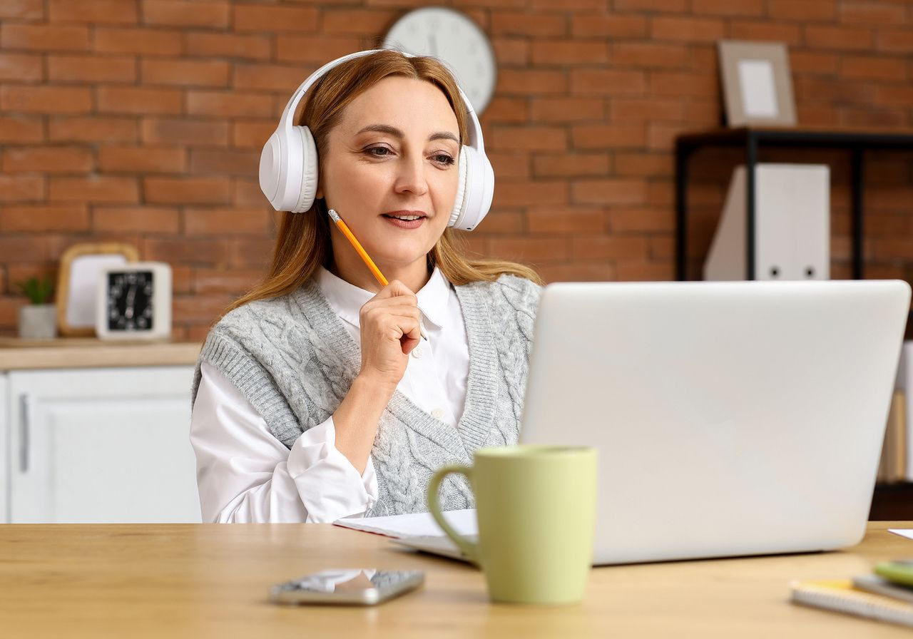 a woman wearing headphones and holding a pencil in her hand