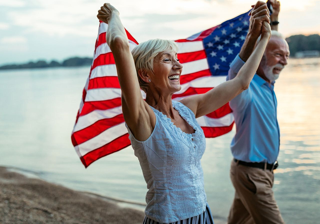 A man and woman proudly hold an American flag, symbolizing patriotism and unity.