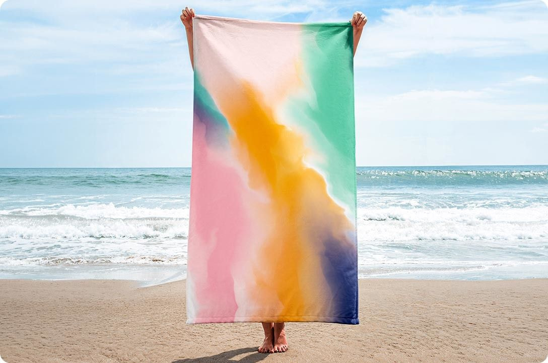 Eine Person, die eine Decke am Strand hält