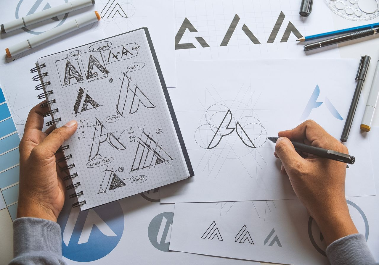 A person is drawing branded symbols.