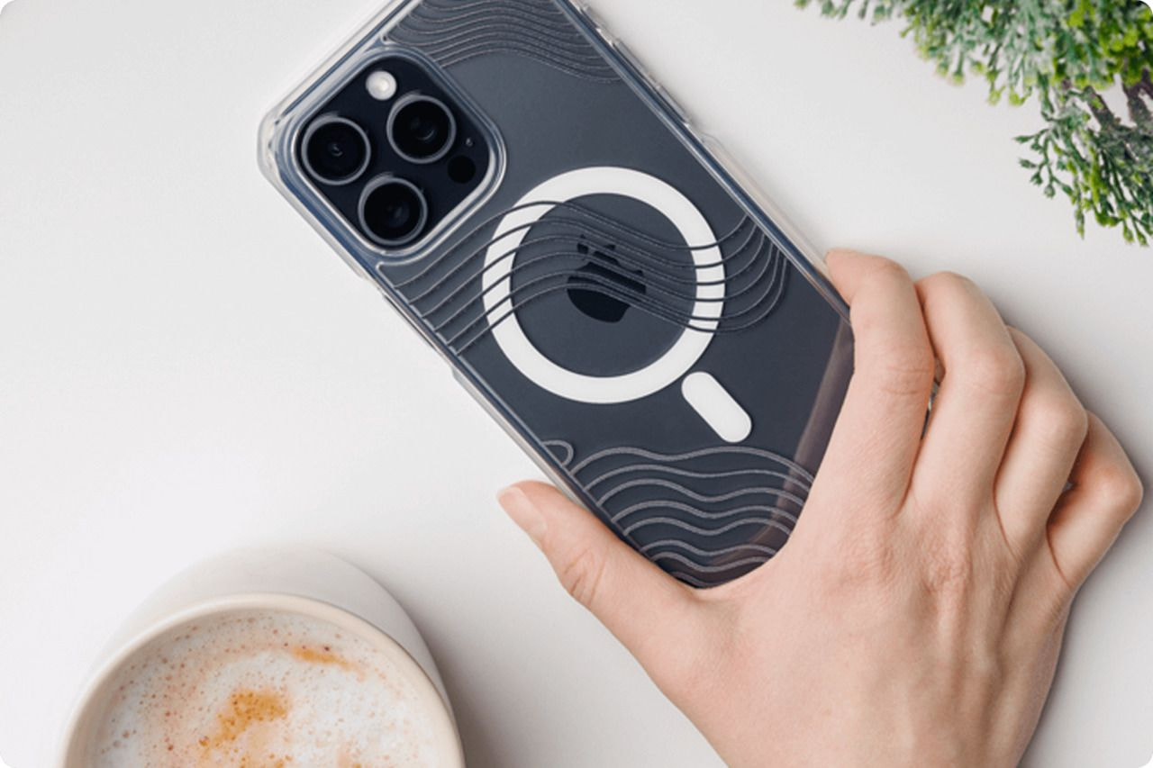 A person holding a phone on a table.