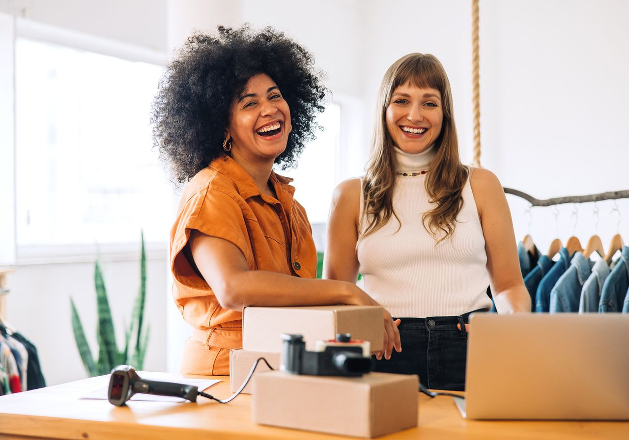 Two women are standing and smiling.
