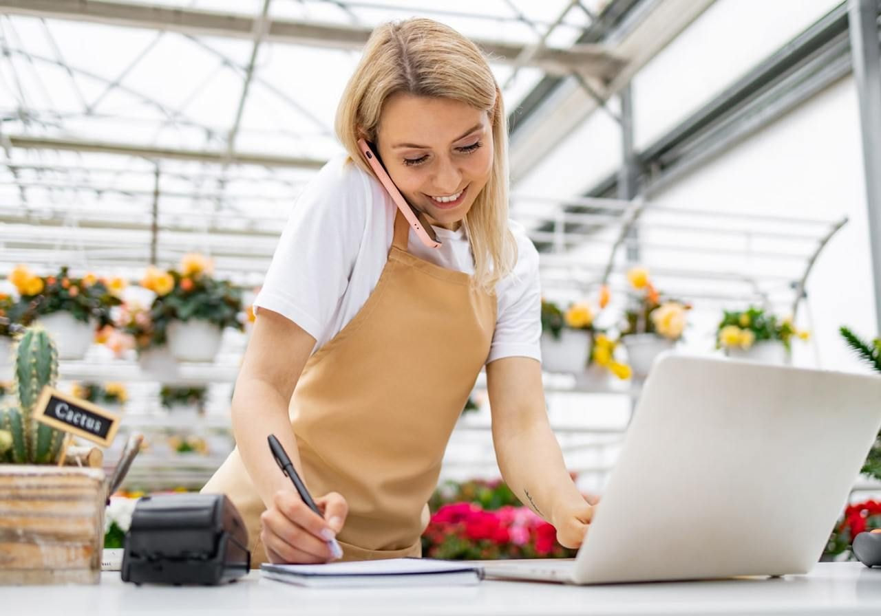 A woman in an apron focused on her laptop, working diligently in a cozy home environment.