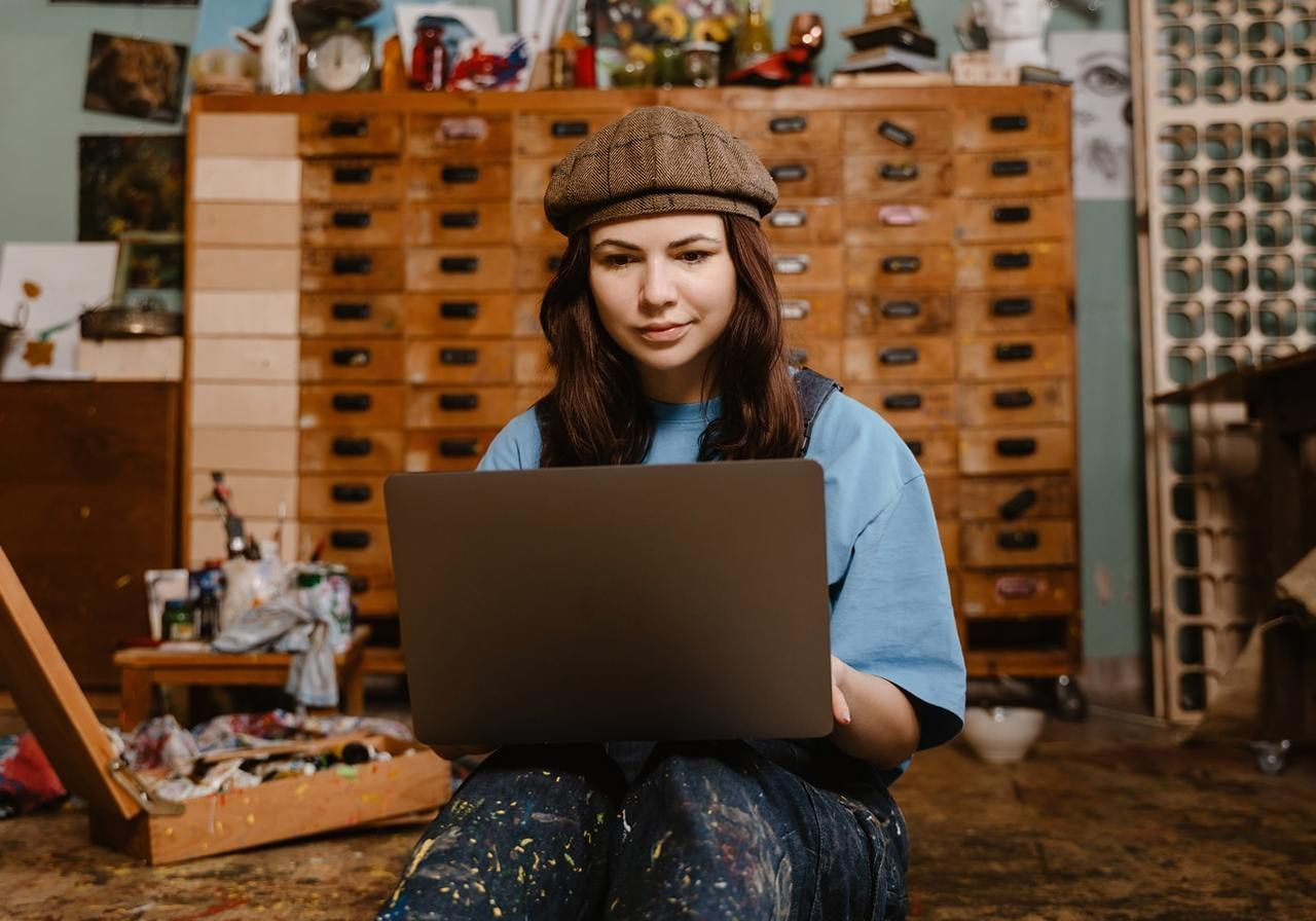 A young woman artist is using a laptop.