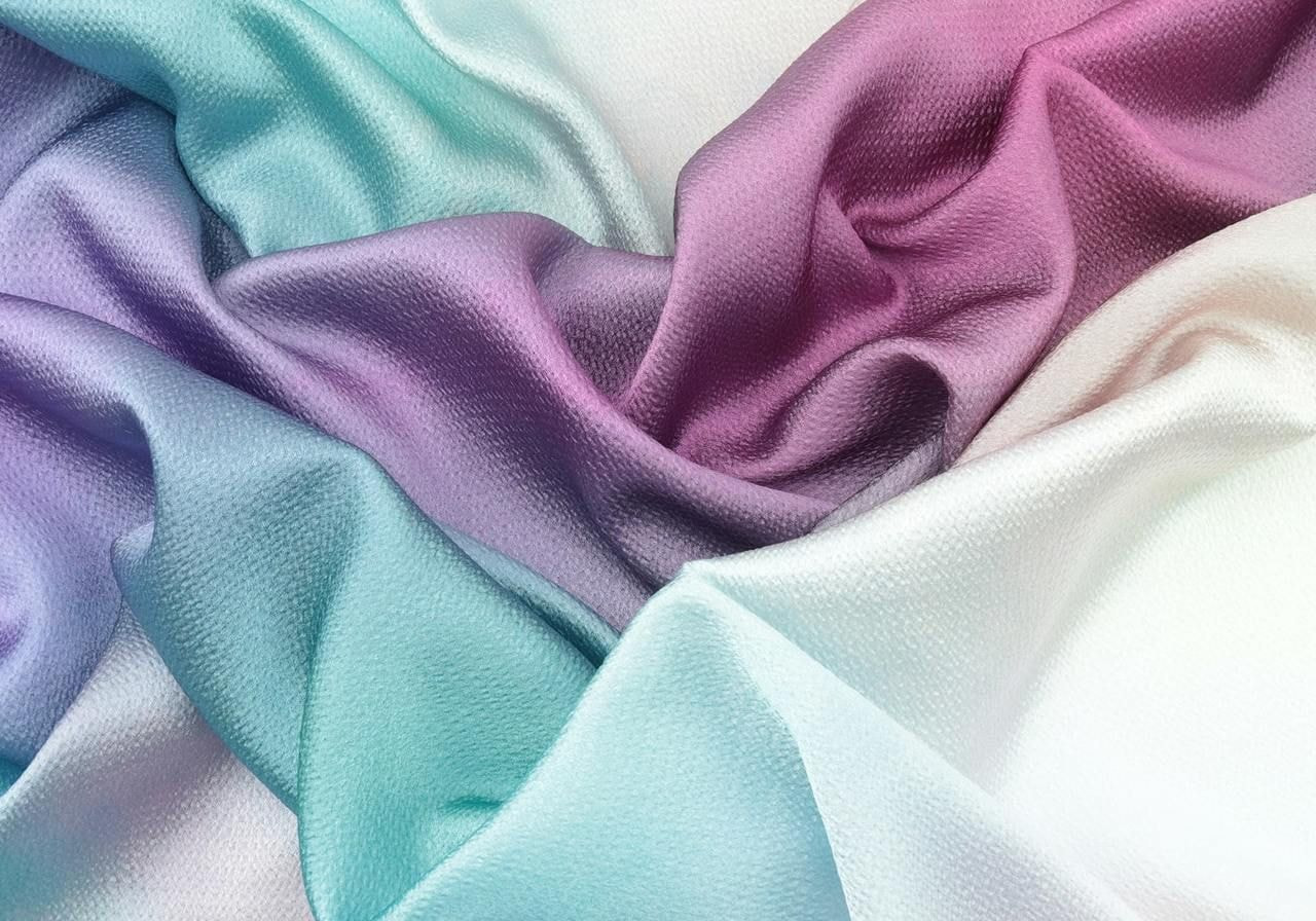 Close-up of vibrant silk fabric showcasing a rich array of colors and intricate patterns.