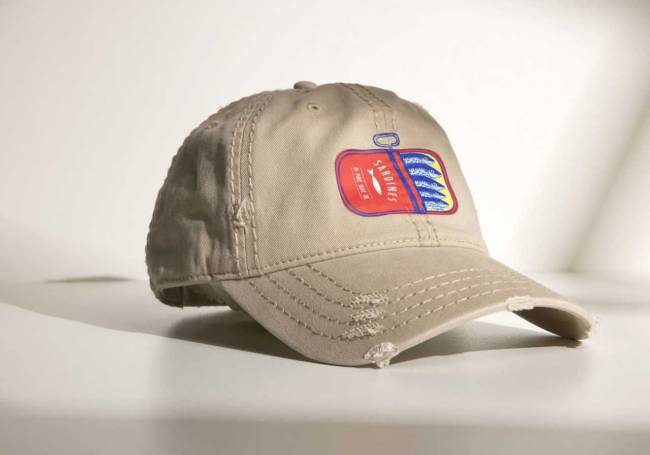 Beige baseball cap with a colorful sardine can patch on the front.
