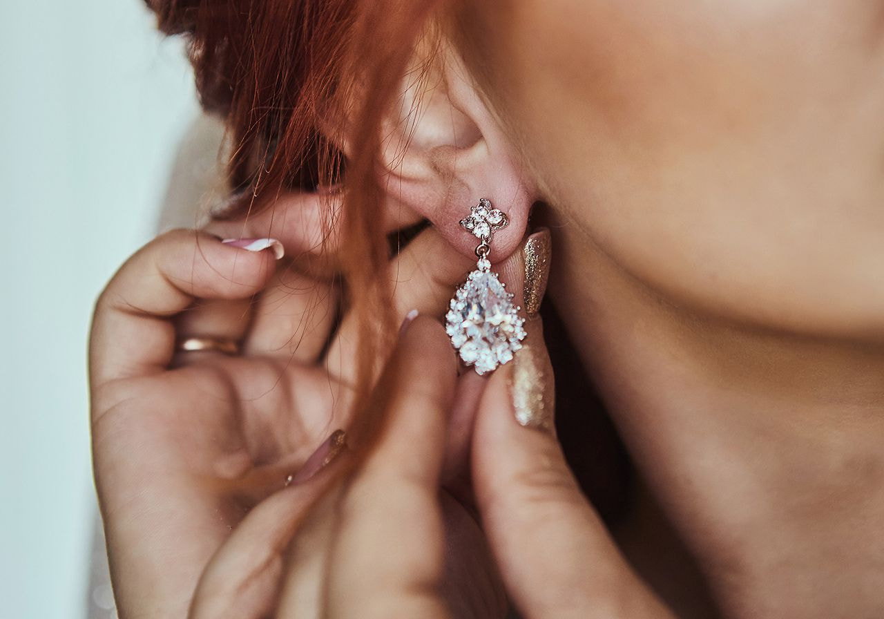 A woman is holding an earring