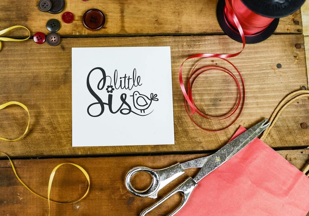 A white “Little sis” greeting card.