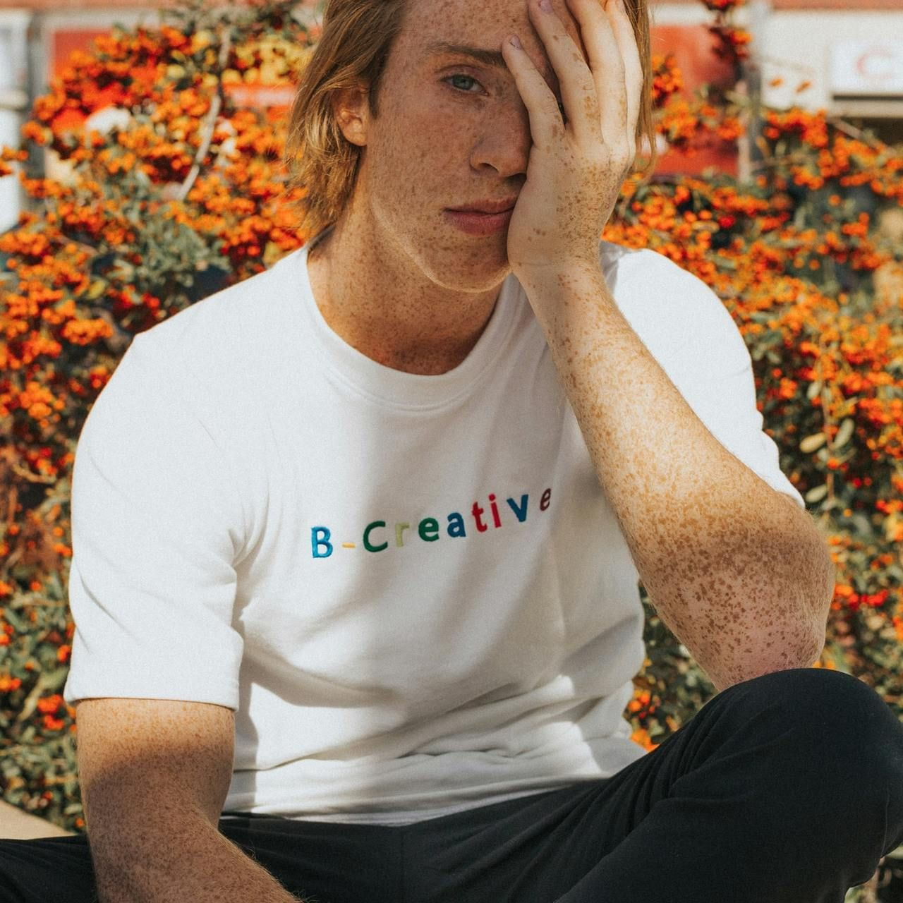 A man on a bench holds his head in his hands, reflecting a moment of deep thought.