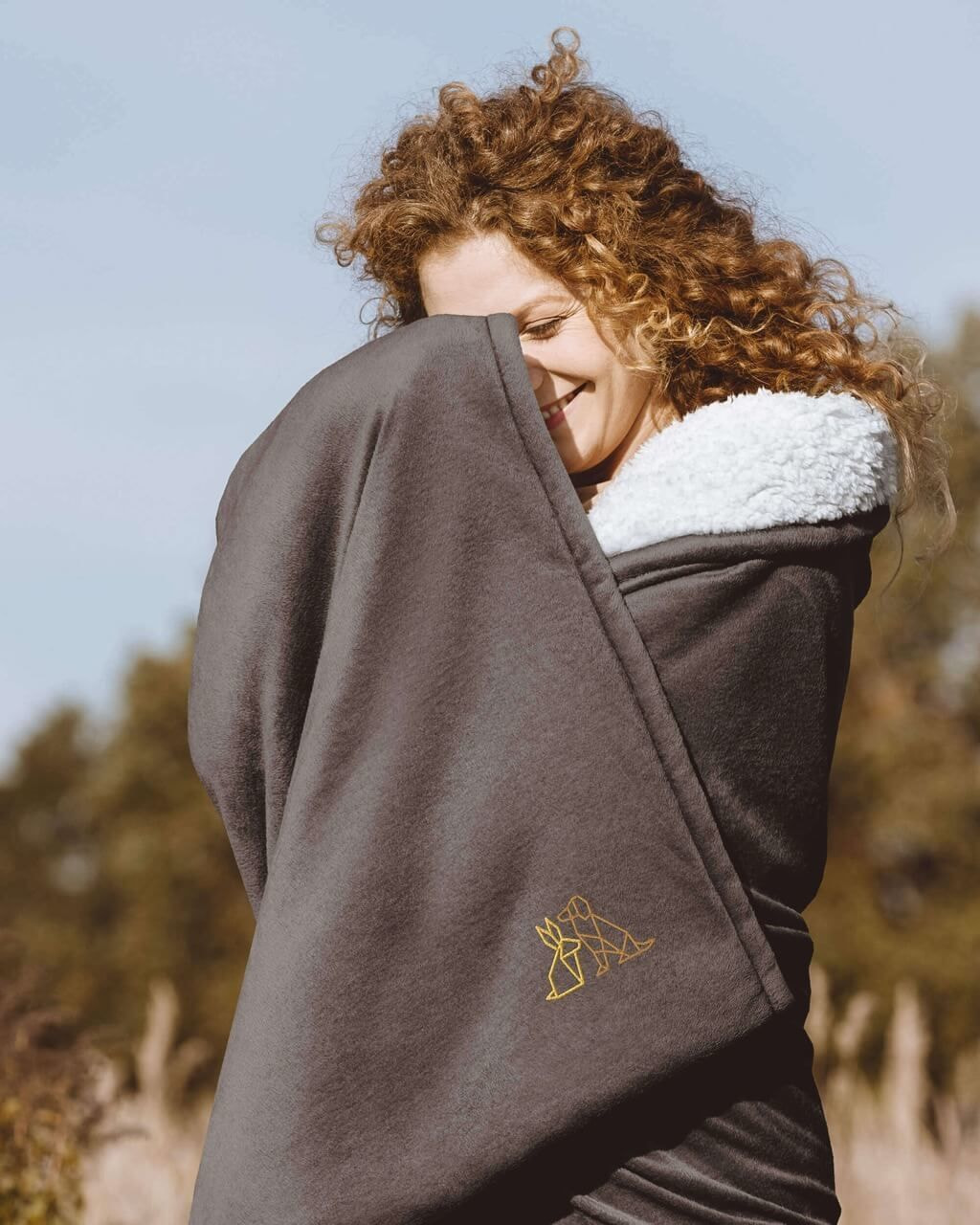 a girl wrapped in an embroidered blanket