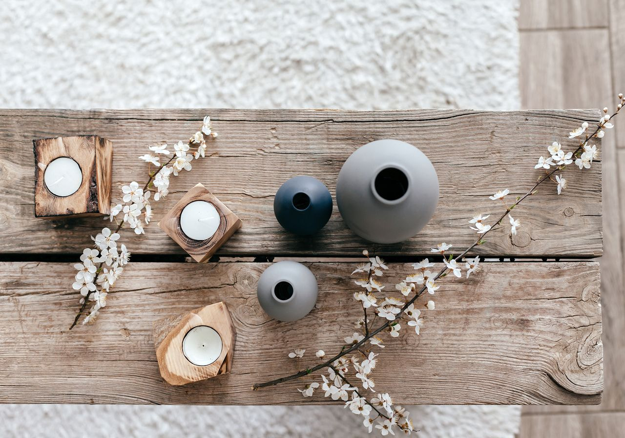 A wooden table adorned with lit candles and a bouquet of colorful flowers, creating a warm and inviting atmosphere.