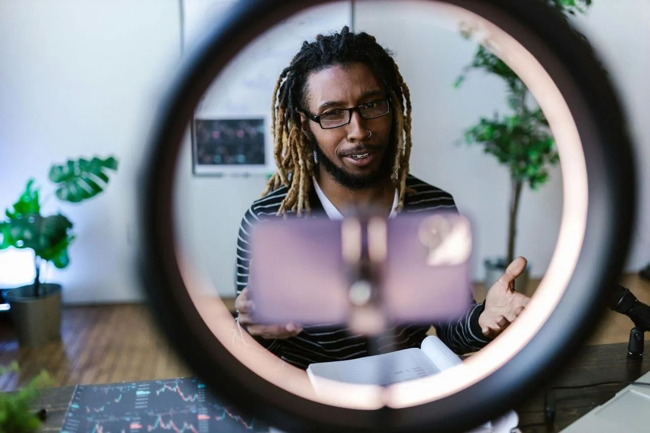 Ein Mann mit Dreadlocks schaut auf ein Telefon