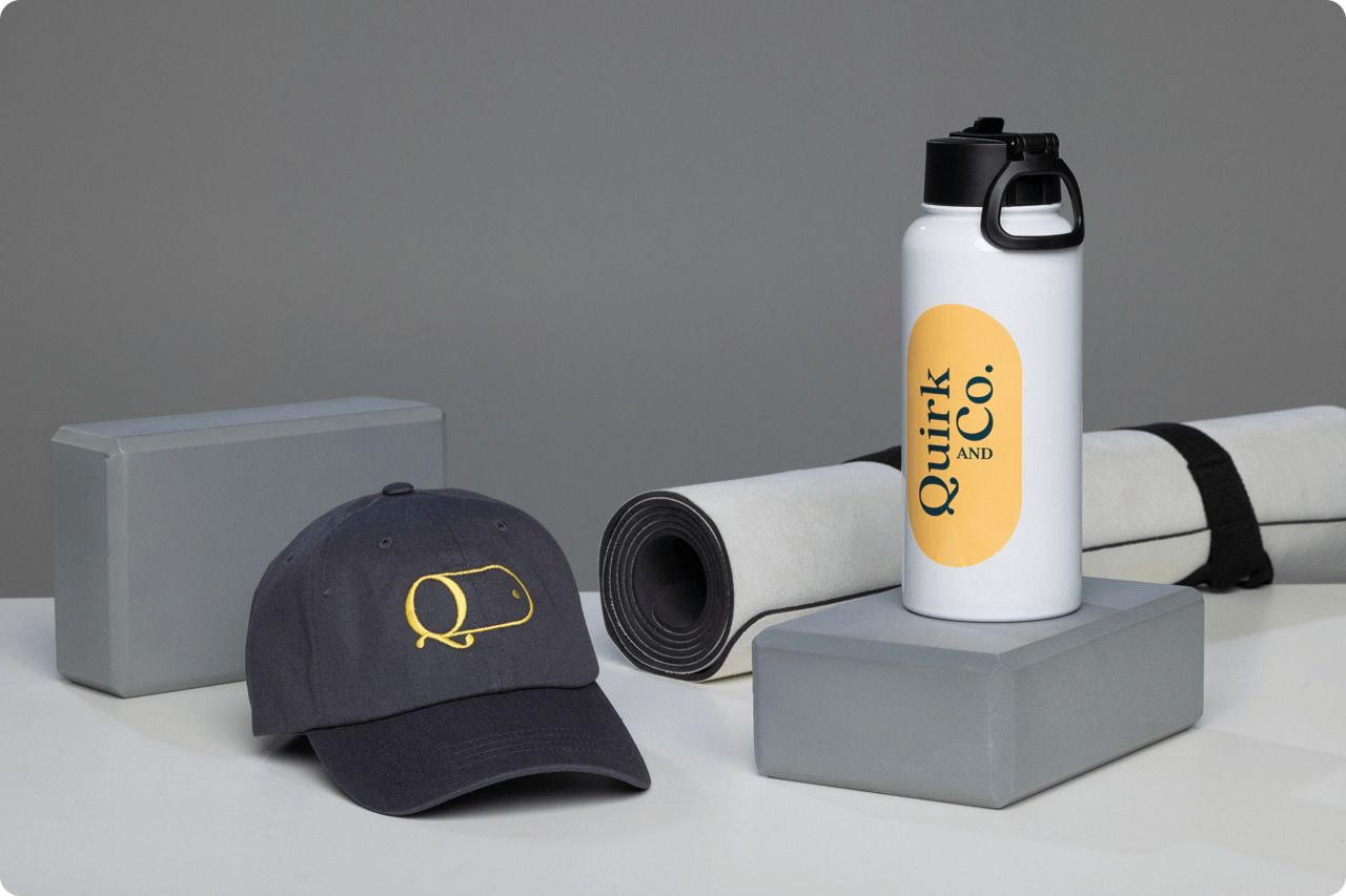A white water bottle, a rolled yoga mat, and a cap arranged neatly on a surface.