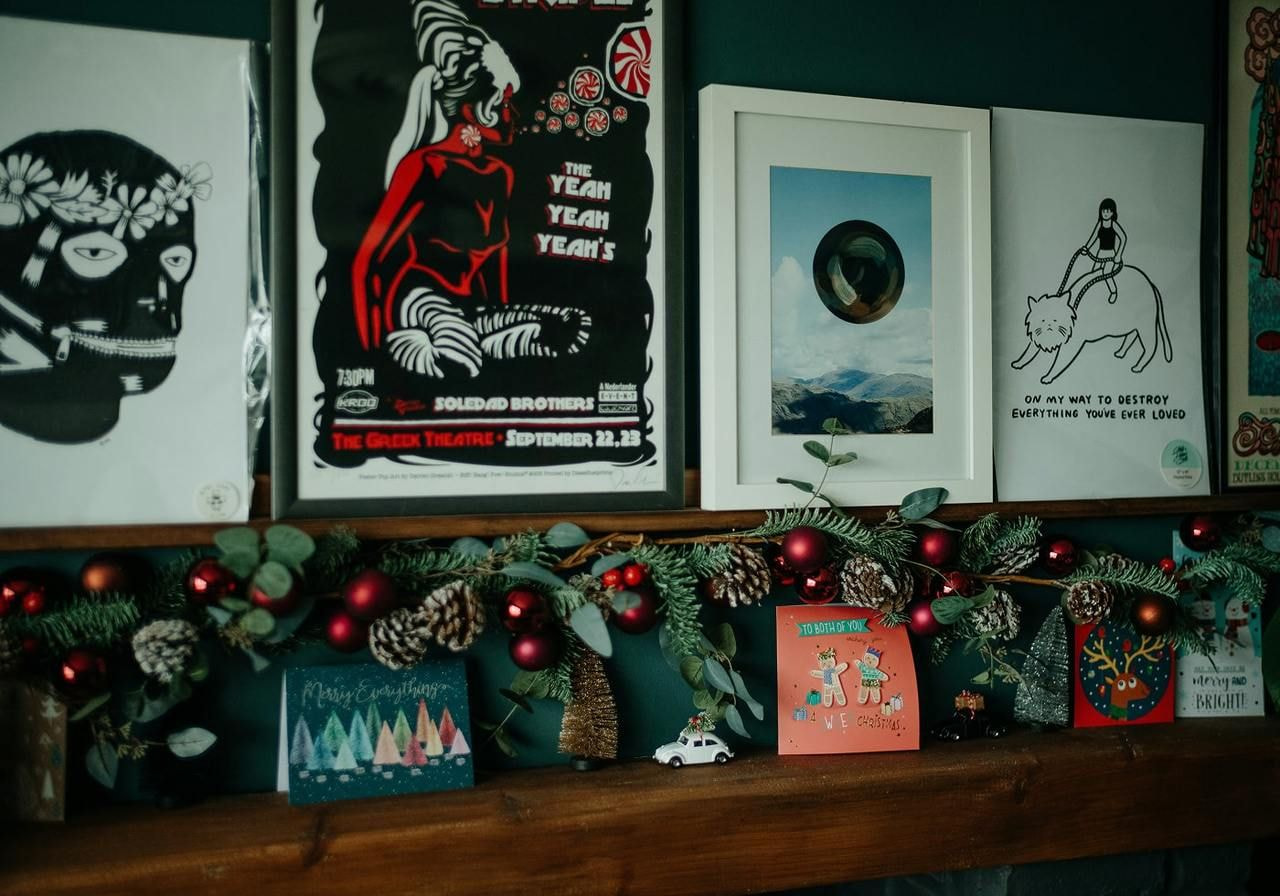 A festive mantle adorned with Christmas decorations, including garlands, ornaments, and candles, creating a warm holiday atmosphere.